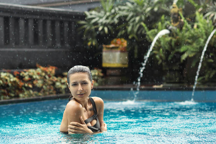 身穿泳装摆在泳池边的性感性感黑毛女人