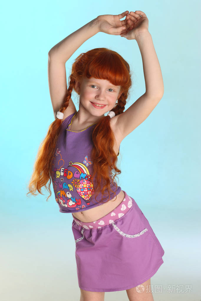 美丽迷人的小红发女孩的肖像.她展示了她的夏季服装.