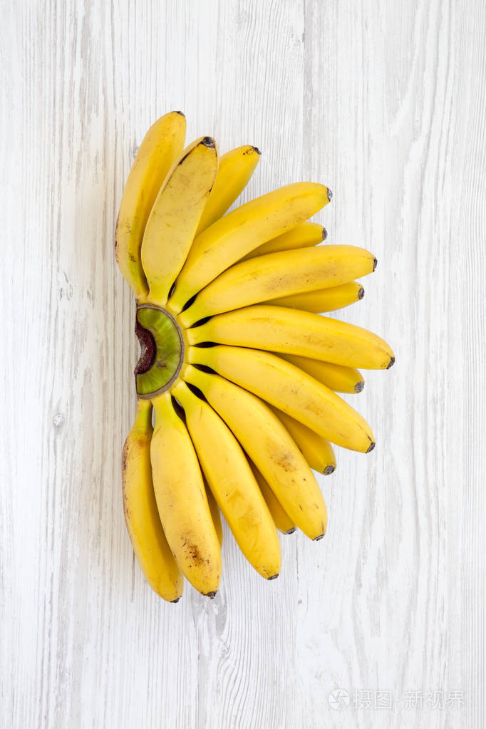 白色木制背景下的一束香蕉俯视