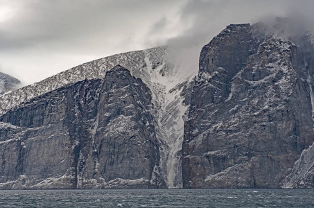 加拿大努纳武特巴芬岛萨姆福特峡湾海岸悬崖上的戏剧性裂缝照片