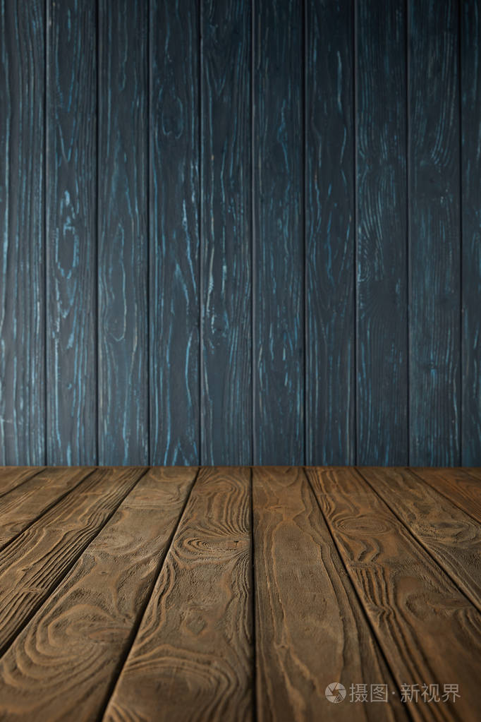 棕色木桌和深蓝色木墙