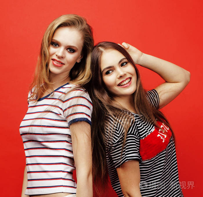 两个最好朋友十几岁的女孩在一起玩乐,造成情绪上红色背景,私交开心的