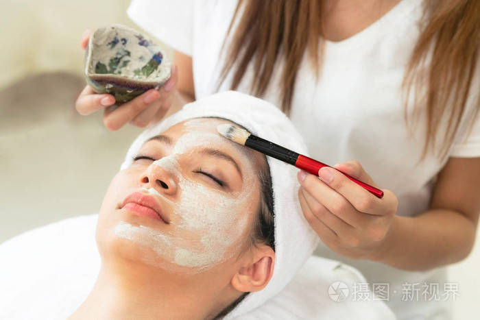 美丽的女人有一个面部美容擦洗治疗从专业皮肤科医生在健康水疗. 抗老