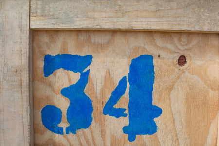 数字34是用蓝色油漆写在木箱上的货物运输的号码粗心的铭文在织物和