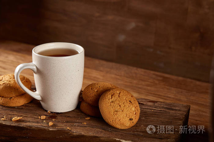 白色瓷杯茶和甜饼干在木片上的木质背景, 顶部视图, 选择性聚焦