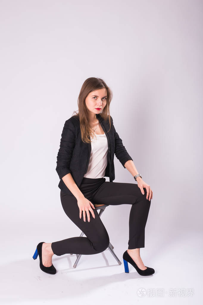 美丽的性女商人坐在椅子上白色背景