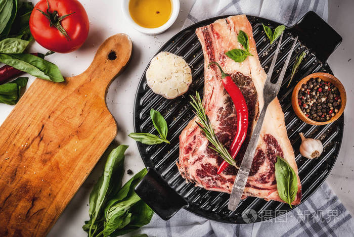 生牛肉大理石肉条纹肋眼牛排香料烤盘和草药白色大理石背景顶部视图