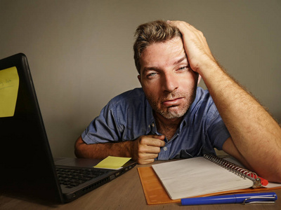 疲劳乏力的人在笔记本电脑上工作会计在记事本上记笔记在疲惫和不知所