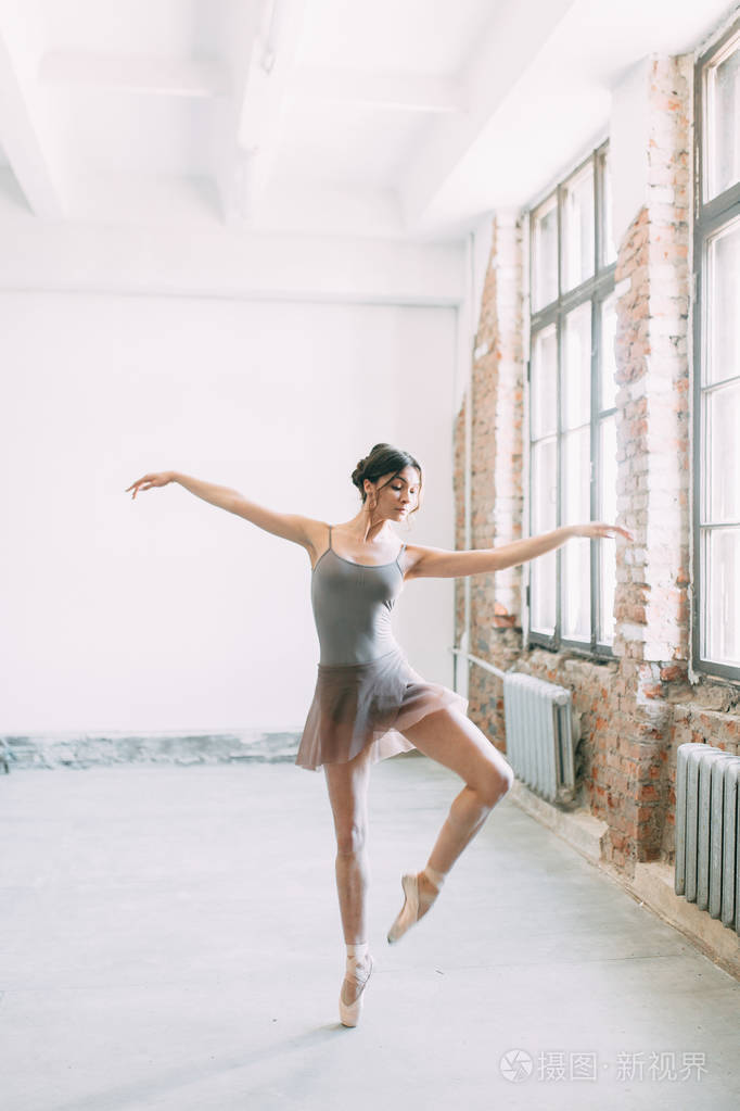 一个年轻的芭蕾舞演员正在准备伸展和跳舞. 在芭蕾里摆姿势.