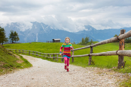 孩子们看着奥地利白雪覆盖的山. 春天的家庭假期.