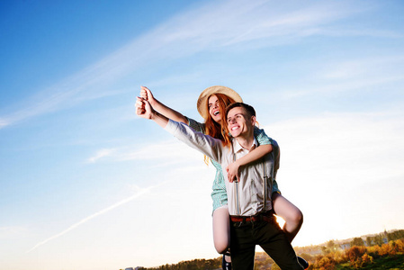 年轻人举起手背着他快乐的女朋友. 快乐的情人做梦.照片