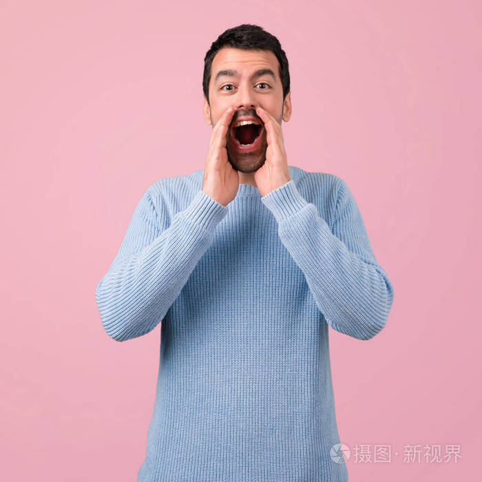 一个英俊的男人在粉红色的背景下大声喊叫