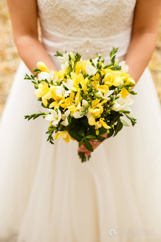 新娘捧着一束黄色的婚礼花束