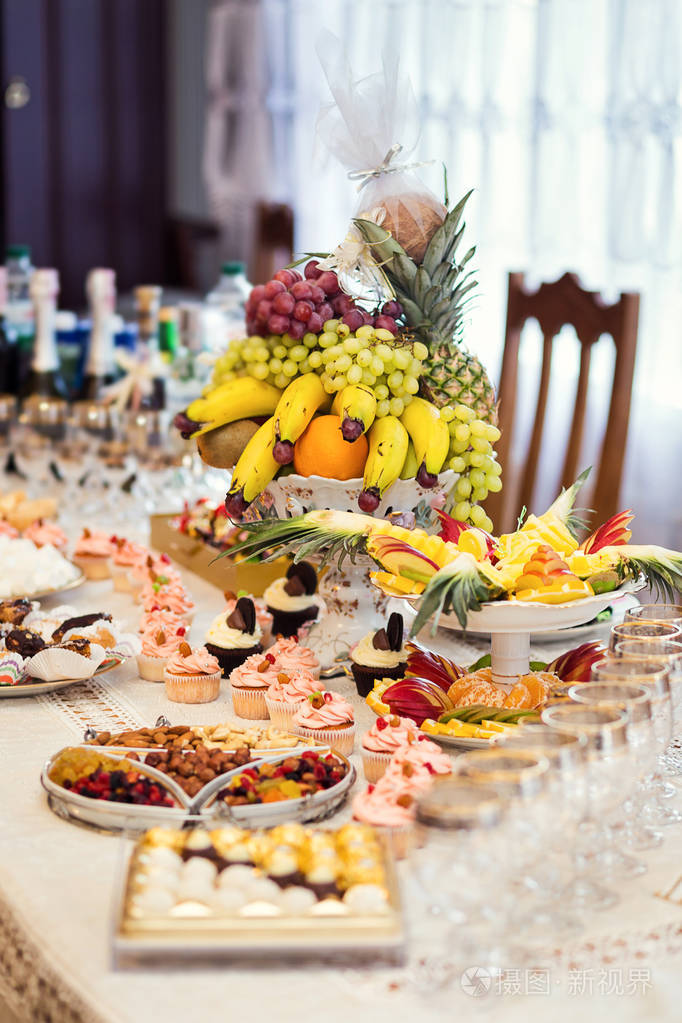 以美味的自助餐装饰的糖果棒,配上纸杯蛋糕和其他甜点/糖果,生日快乐