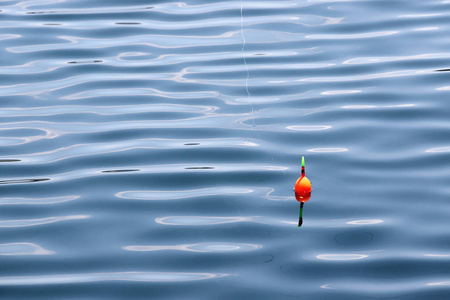 钓鱼漂浮在水面上,有波浪和美丽的倒影照片
