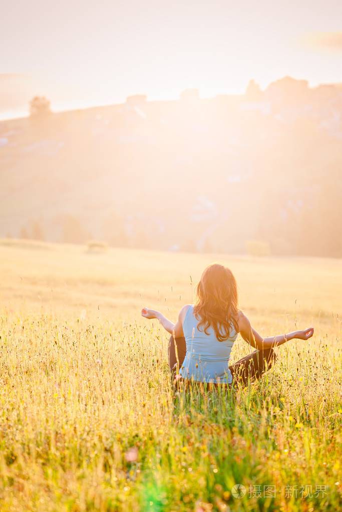 女性在阳光明媚的早晨享受生活山上快乐的年轻女人松弛概念