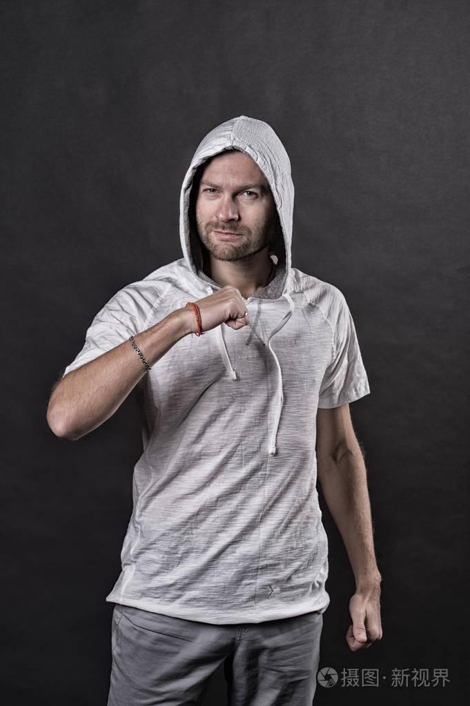 时尚模特握紧拳头手势.穿着休闲运动衫的大胡子男子.