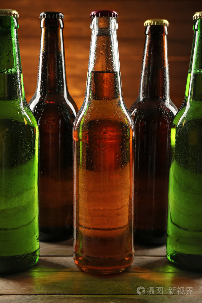 木制桌子上玻璃瓶中的新鲜啤酒