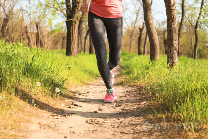 运动的年轻女人在公园里跑步