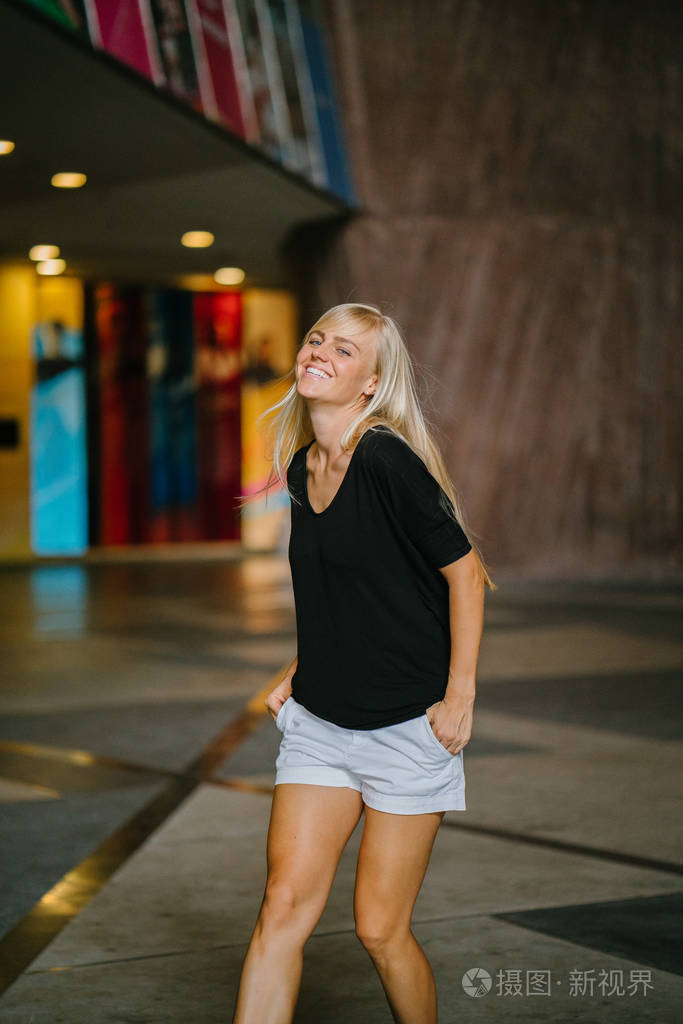 她穿着舒适的运动休闲装和运动鞋,走路时微笑着