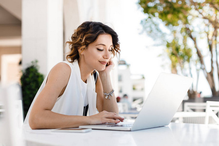 智能手机上看卡通拥有笔记本电脑业务团队的商务女性在她的办公室工作