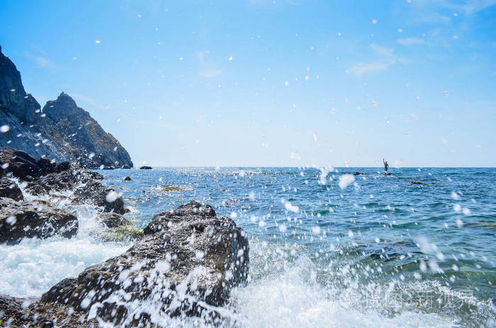 美丽的海浪,飞溅的水.海岸上的岩石和石头.夏日阳光明媚.