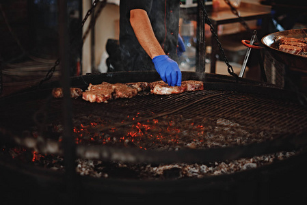 烤肉烤. 男人把肉放在烤架上. 街头美食.照片
