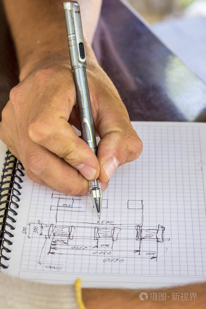 建筑工人绘制了房子的草图用钢笔画画的手