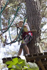 在绳游乐园里有攀爬设备的少女图片