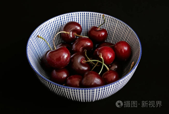 红色樱桃在碗中,黑色背景