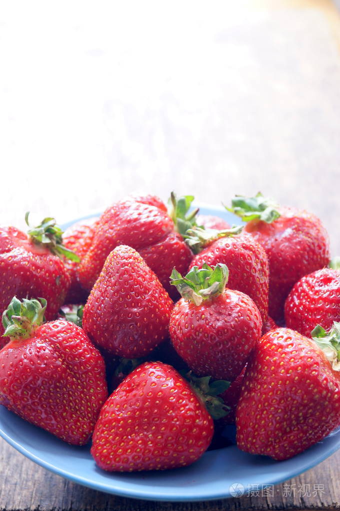 在木桌上的碗里放新鲜的草莓.素食主义, 纯素食.