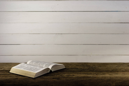 书结婚戒指, 皇冠和圣经在桌子上的十字架和玻璃藤在木制背景上打开