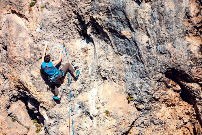 一个人爬上岩石在大自然中攀爬户外健身积极的生活方式极限运动运动员