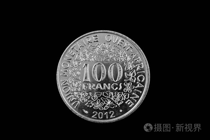 一张在黑色背景上孤立的100西非法郎银币的特写照片