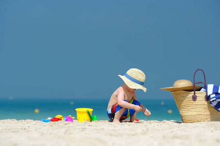 两岁小孩在沙滩上玩沙滩玩具照片