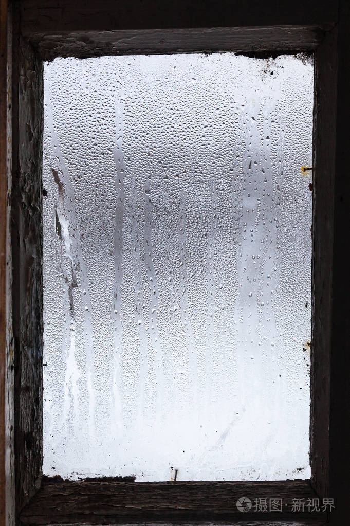 冬天旧农村房子里雾蒙蒙的窗户表面的冰融化的水