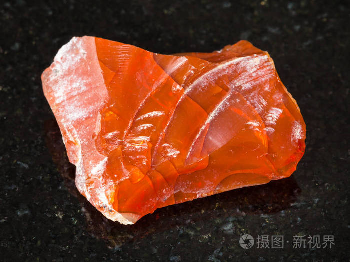 从乌拉尔山的黑色花岗岩上拍摄天然矿物粗糙的火蛋白石宝石