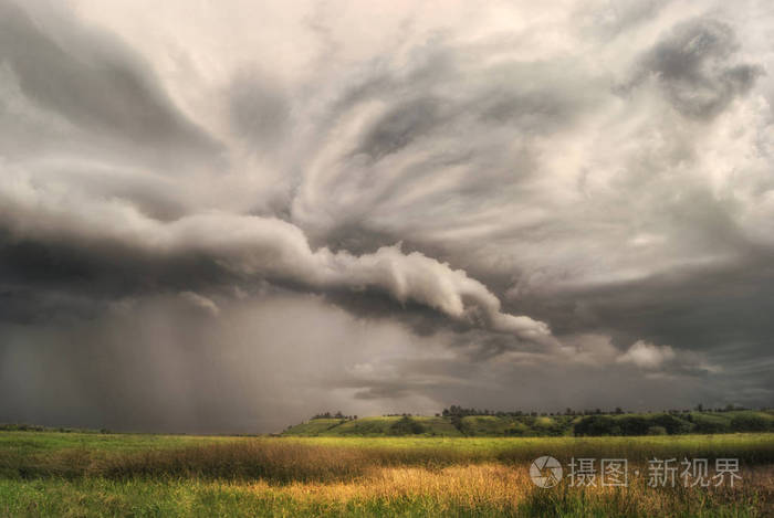 飓风风暴在田野和草地上接近丘陵山谷. 阴雨天.