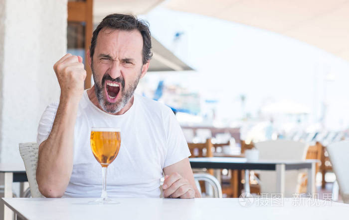 帅气的大四男生在餐厅喝啤酒恼羞成怒地大喊大叫,疯狂地举起手大喊