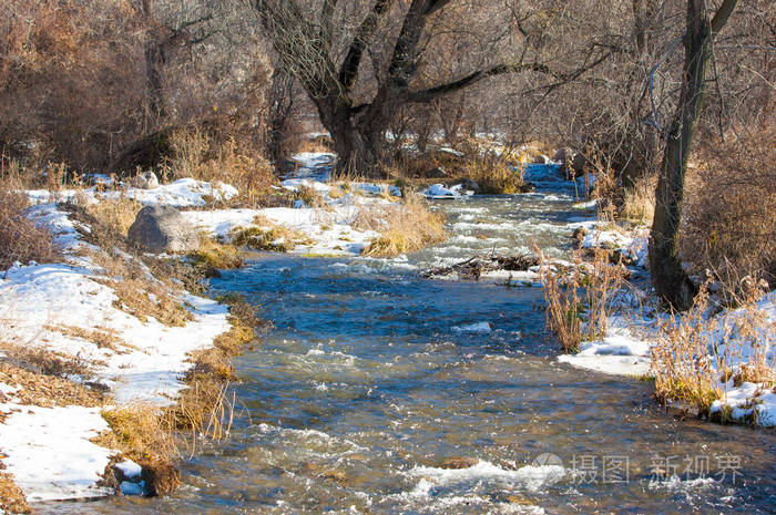 早春时小河里的流水春天的景象带冰溪的山景