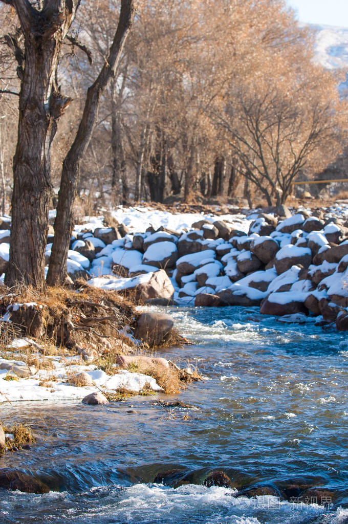 早春时小河里的流水春天的景象带冰溪的山景