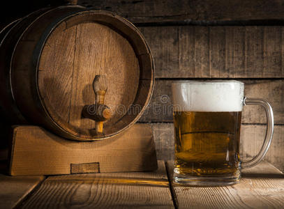 啤酒桶，木制背景上有啤酒杯