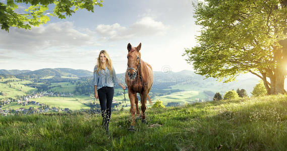 美丽的金发女孩和一匹马在美妙的风景