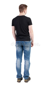 穿牛仔裤的男人的后视图。站着的年轻人。