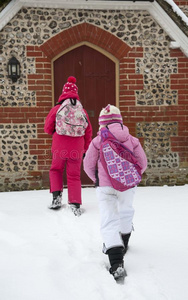 孩子们在雪地里走到学校大楼