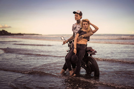 时尚情侣站在海边摩托车旁图片
