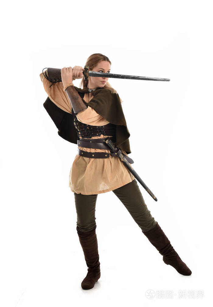 穿着棕色中世纪战士服装的金发女孩的全长肖像.