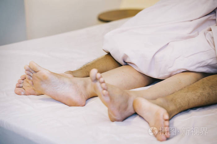 把男女的脚贴在床上