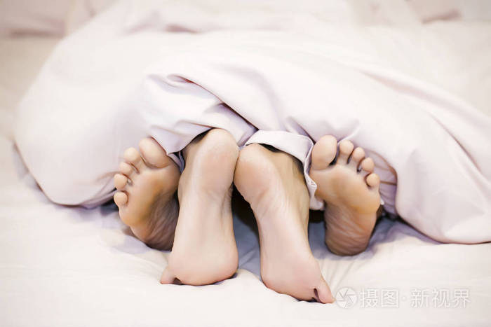 把男女的脚贴在床上