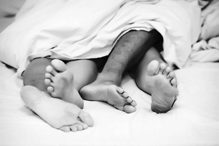 白色的脚上贴一个修补程序把男女的脚贴在床上婴儿的手和脚拼贴的特写